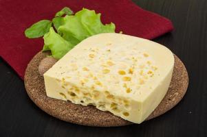 Fromage jaune sur planche de bois et fond de bois photo