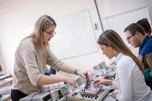 étudiants faisant la pratique dans la salle de classe électronique photo