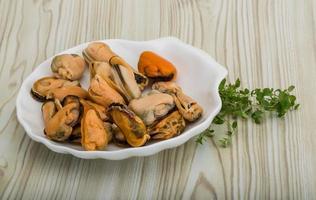 moules dans un bol sur fond de bois photo