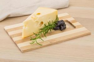 Fromage maasdam sur planche de bois et fond de bois photo