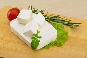 Fromage feta sur planche de bois et fond de bois photo