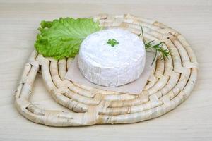 Fromage brie sur planche de bois et fond de bois photo