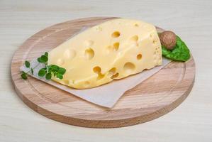 Fromage jaune sur planche de bois et fond de bois photo