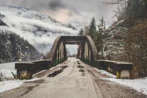 un pont en béton dans les montagnes enneigées photo