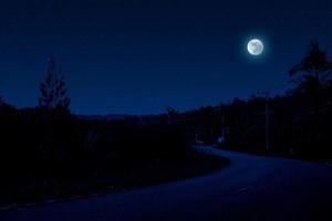 scène de nuit dans un village avec une route vide photo