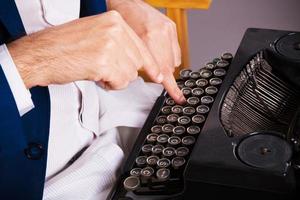 gros plan d'un homme écrivant sur une machine à écrire. photo
