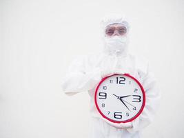 portrait d'un médecin ou d'un scientifique en uniforme de suite epi tenant un réveil rouge et regardant la caméra dans divers gestes. concept covid-19 isolé fond blanc photo