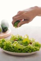 petit-déjeuner végétalien vert dans un bol avec laitue, concombre, citron vert et amande. fille tenant la plaque avec les mains visibles, vue de dessus. alimentation propre, régime, concept de nourriture végétalienne photo