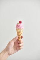 cornet de crème glacée isolé. la femme tenant la glace à la main. photo