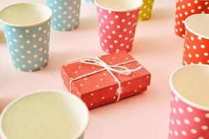 composition à plat avec boîte-cadeau rose vif, pailles à boire, ruban et confettis. photo