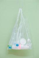 sac en plastique rempli de déchets ménagers isolé sur fond blanc. photo