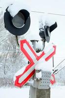 le sémaphore est situé sur l'autoroute traversant la voie ferrée en hiver photo