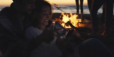 couple profitant d'un feu de joie avec des amis sur la plage photo