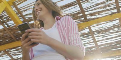 femme smartphone textos sur téléphone portable à la plage photo