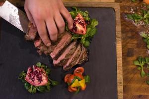 vue de dessus des mains du chef préparant un steak de boeuf photo