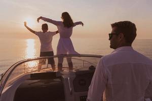 un couple de personnes âgées en tenue décontractée avec leur fils profite d'un bateau en mer au coucher du soleil. le concept d'une famille heureuse. mise au point sélective photo