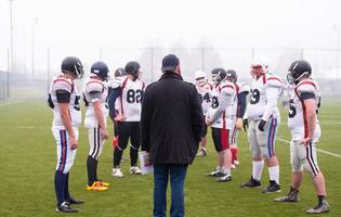 joueurs de football américain discutant de stratégie avec l'entraîneur photo