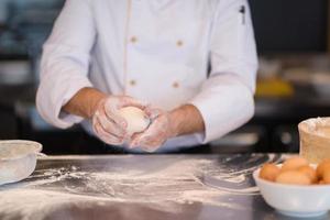 mains de chef préparant la pâte pour la pizza photo