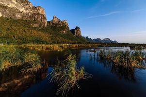 pont en bois dans le lac de lotus sous un ciel nuageux au parc national de khao sam roi yod, thaïlande. photo