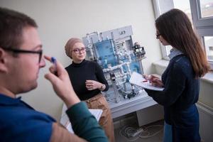 jeunes étudiants faisant la pratique dans la salle de classe électronique photo