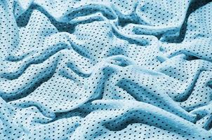 fond de texture de tissu de vêtements de sport bleu. vue de dessus de la surface textile en tissu bleu clair. maillot de basket lumineux. espace de texte photo