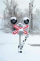 le sémaphore est situé sur l'autoroute traversant la voie ferrée en hiver photo