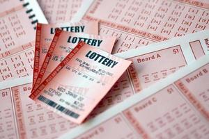 le billet de loterie rouge se trouve sur des feuilles de jeu roses avec des numéros pour marquer pour jouer à la loterie. concept de jeu de loterie ou dépendance au jeu. fermer photo
