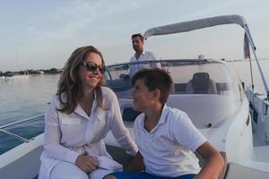 un couple de personnes âgées en tenue décontractée avec leur fils profite d'un bateau en mer au coucher du soleil. le concept d'une famille heureuse. mise au point sélective photo