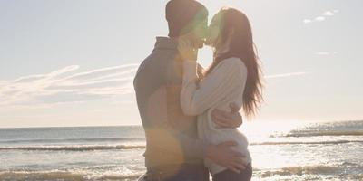 couple s'amusant lors d'une belle journée d'automne à la plage photo