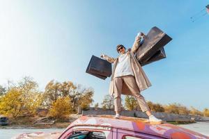 une jeune femme est debout dans une voiture avec des sacs dans les mains photo