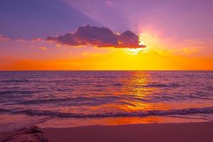 beau coucher de soleil sur la mer sur la plage tropicale avec ciel et nuages pour voyager en vacances se détendre photo