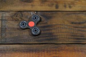 un rare spinner en bois fait à la main se trouve sur une surface de fond en bois marron. jouet anti-stress tendance photo