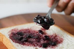 confiture de baies bleues sur du pain sur table, photo