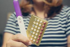 jeune femme regardant un spectacle à la main lors de la vérification du kit de test de grossesse. elle vérifie son examen de grossesse. succès félicitations nouvelle maman. photo