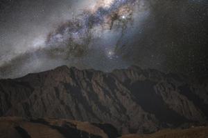 paysage nocturne, chaîne de montagnes, rochers, pics de pierre sur fond de ciel nocturne avec étoiles et voie lactée, sinaï. photo