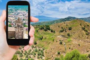 touriste prenant une photo de la ville sur la pente de l'etna