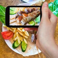 Touriste prenant une photo de brochettes mélangeant des brochettes arabes