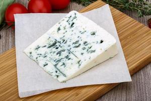 Fromage bleu sur planche de bois et fond de bois photo