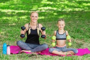 une femme avec une fille s'entraîne dans le parc. photo