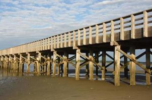 long pont de bois qui s'étend sur une baie à la plage photo