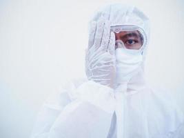 photo d'un médecin ou d'un scientifique asiatique en uniforme de suite d'epi couvrant un œil avec la paume. coronavirus ou covid-19 concept isolé fond blanc