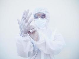 médecin ou scientifique asiatique en uniforme de suite epi mettant des gants blancs de protection tout en regardant les mains. concept covid-19 isolé fond blanc photo