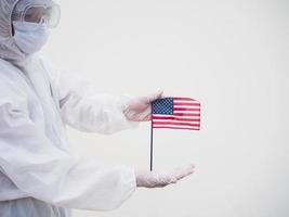 portrait d'un médecin ou d'un scientifique en uniforme de suite epi tenant le drapeau national des états-unis d'amérique. concept covid-19 isolé fond blanc photo