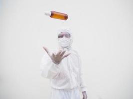 portrait d'un médecin ou d'un scientifique en uniforme de suite epi tenant une bouteille en plastique avec un produit de soin de la peau. concept covid-19 isolé fond blanc photo