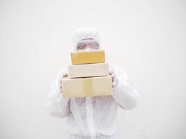 jeune homme en uniforme de suite epi tout en tenant des boîtes en carton dans des gants et un masque en caoutchouc médical. coronavirus ou covid-19 concept isolé fond blanc photo