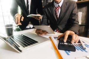 femme entrepreneur utilisant une calculatrice avec un stylo à la main, calculant les dépenses financières au bureau à domicile photo