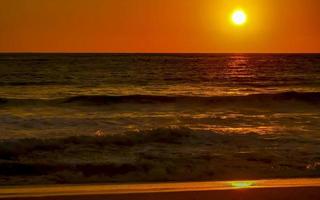 coucher de soleil doré coloré grande vague et plage puerto escondido mexique. photo