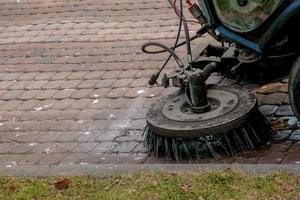 le service municipal effectue des travaux saisonniers dans le parc. la balayeuse ramasse beaucoup de débris. les brosses balayent l'asphalte photo