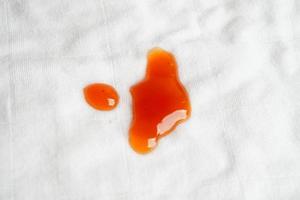 tache de sauce épicée sale sur un chiffon à laver avec de la lessive en poudre, concept de nettoyage des travaux ménagers. photo