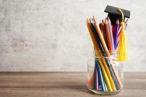 chapeau de graduation avec des crayons colorés sur un livre avec espace de copie, apprentissage du concept d'éducation universitaire. photo